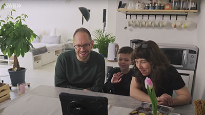 Reporter am Küchentisch einer Mutter und Ihrem Sohn